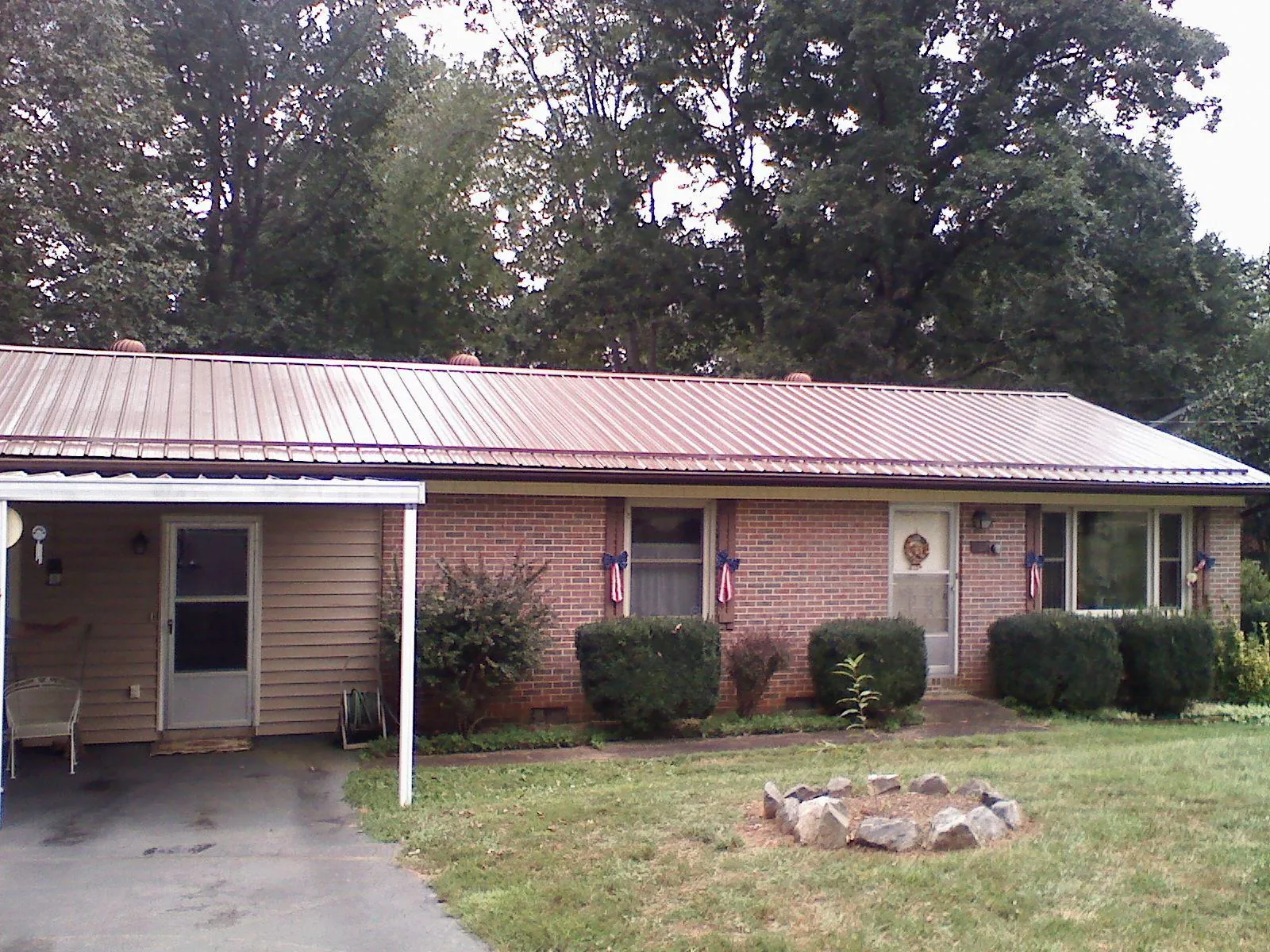 Bronze metal roof and carport on a brick ranch home — Roof Repair work by our crew in Harrah
