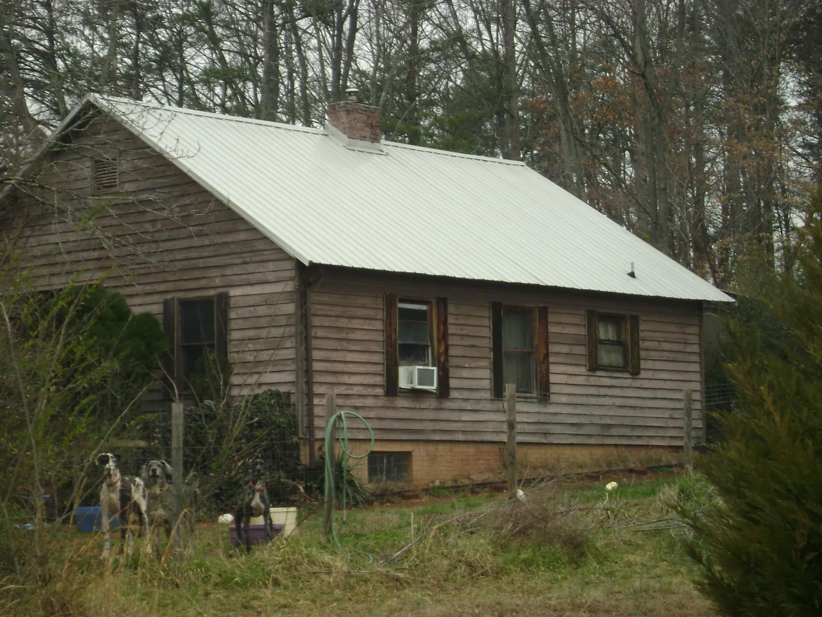 White metal roof on an old wood sided farmhouse, from a Metal Roof Installation job in Harrah